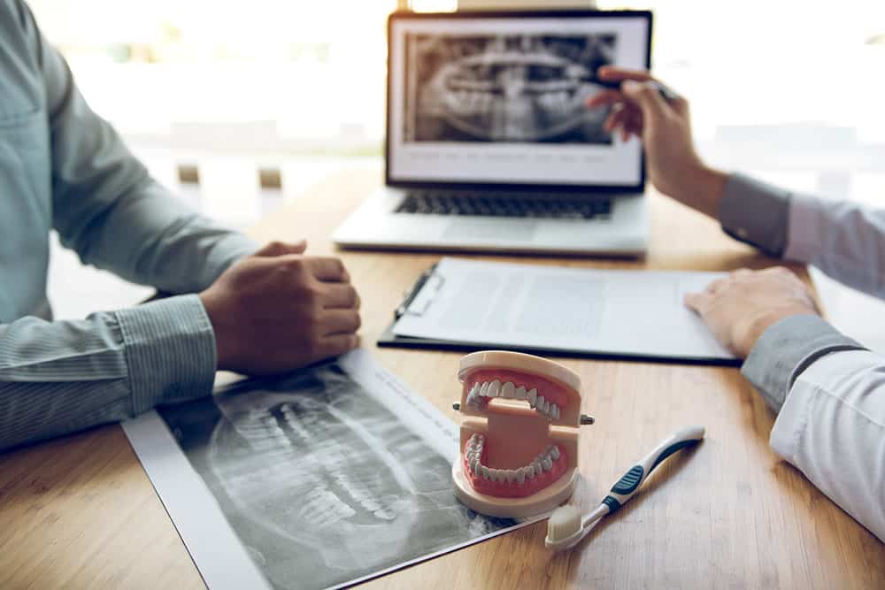 Two people examining a dental xray