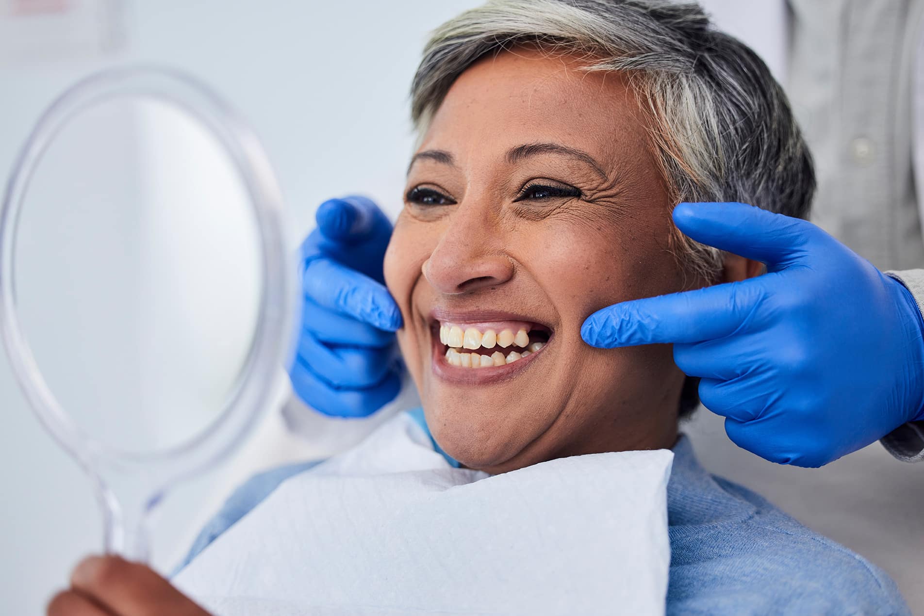 senior woman smiling with dentist at twin oaks dentistry